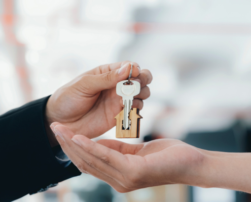 Real estate agent holding key with house shaped keychain